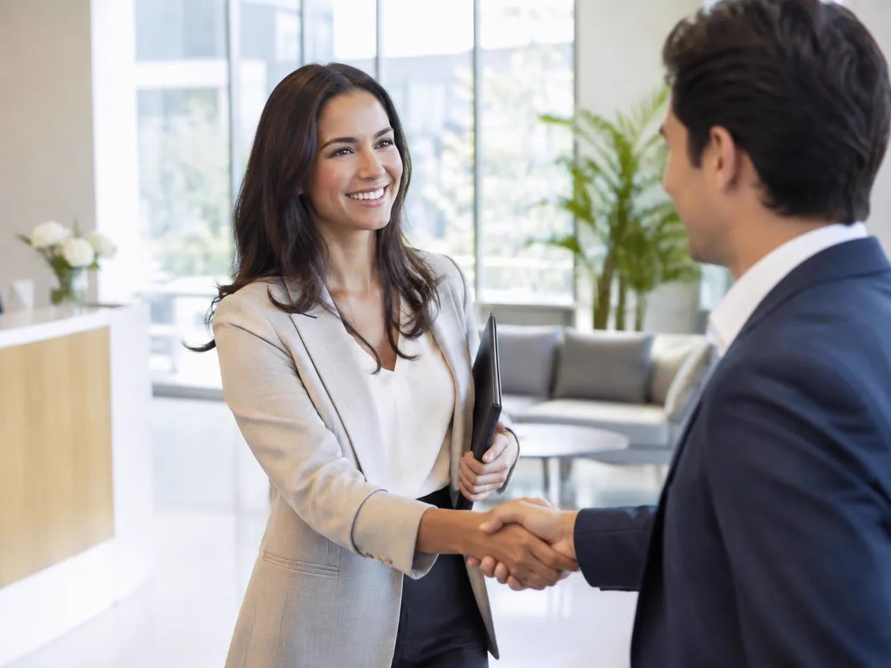Recruiter welcoming a candidate with a handshake in a modern office lobby